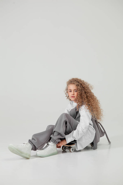 curly haired girl in sportswear in the studio - Фото, изображение