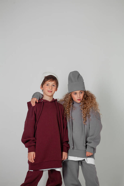 long-haired girl and boy in tracksuits - Foto, afbeelding
