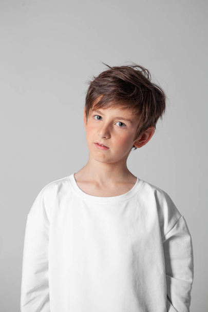 молодий хлопчик у білій футболці з довгим рукавом
 - Фото, зображення