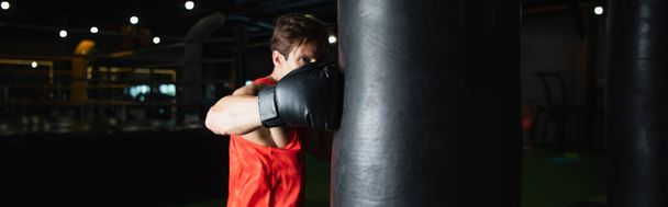 boxer exercising with punching bag in sports center, banner - Photo, Image