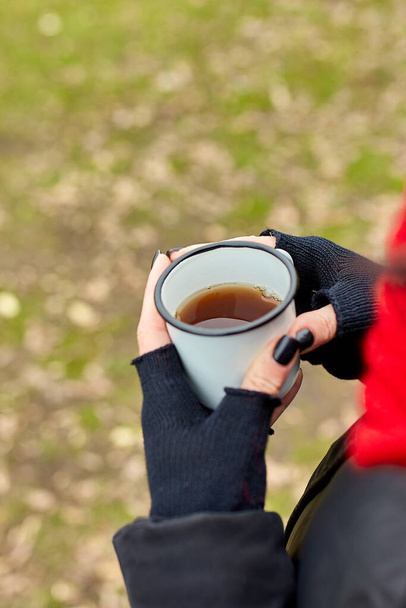 Mujer en sombrero rojo y bufanda, beber té de la taza de metal al aire libre, concepto de viaje, paisaje de fondo de otoño. - Foto, Imagen
