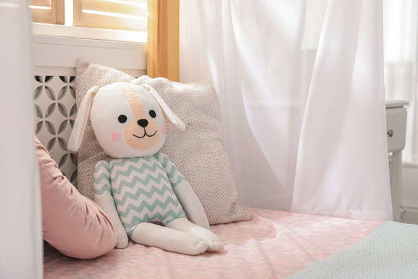 Toy dog on bed in child's room. Space for text - Photo, image