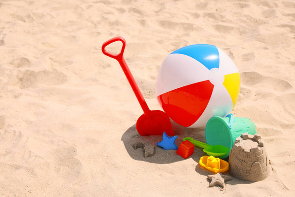 Different beach toys and inflatable ball on sand outdoors, space for text - Фото, зображення