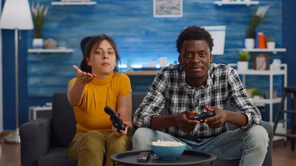 Modern interracial couple losing video game on TV - Photo, Image