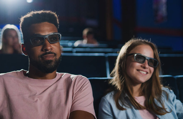Cheerful young couple with 3d glasses in the cinema, watching film. - Zdjęcie, obraz