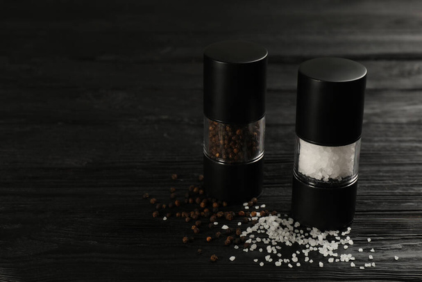 Sůl a pepřák na černém dřevěném stole, detailní záběr. Mezera pro text - Fotografie, Obrázek