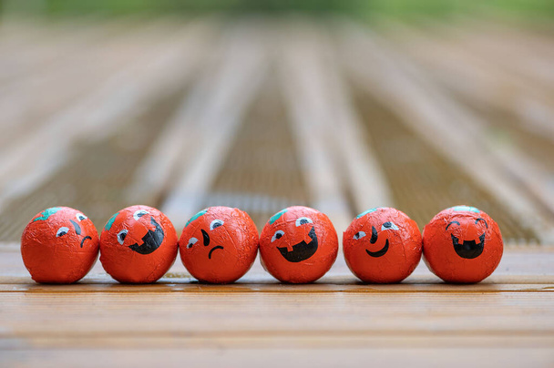 Хеллоуїн прикраси фон з низкою гарбузів цукерки цукерки з емоціями обличчя на дерев'яній терасі
  - Фото, зображення