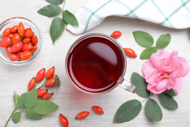 Flat lay composition with aromatic rose hip tea on white wooden table - Photo, Image