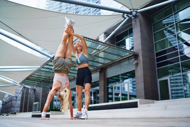 Two women doing exercise outdoors in city, healthy lifestyle concept. - Fotó, kép