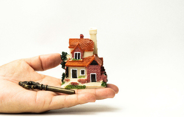 A model house and a key on human hand and stack of coins and Isolate on white background. Concept ideas for Financial housing plan. Concept ideas , Save up for a new house. - Photo, Image