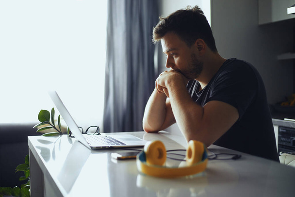 El hombre perdido en pensamientos delante de la computadora portátil, el pensamiento masculino de la solución del problema - Foto, Imagen