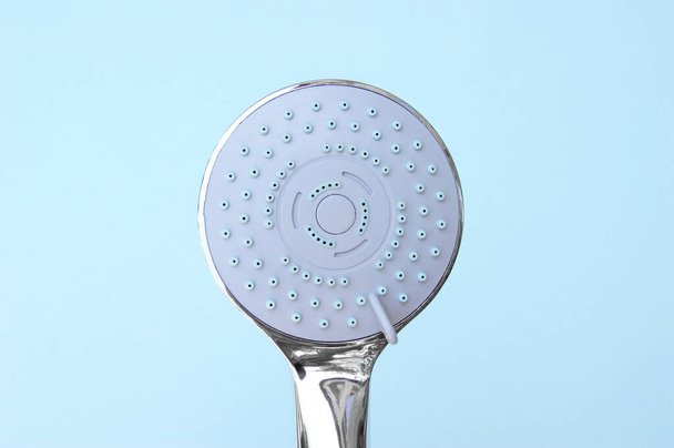 Душевая головка с хромированным покрытием мульти-режим для ванной комнаты со шлангом на синем фоне. - Фото, изображение