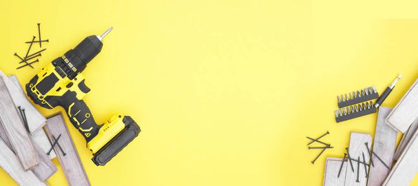 Yellow-black screwdriver on a yellow background, screws, a set of bits. Copy space. - Photo, Image