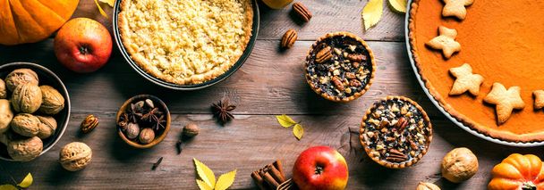 Thanksgiving autumn pies on wooden background, banner. Fall homemade pumpkin, apple and pecan pies and ingredients for autumn holidays. - Photo, Image