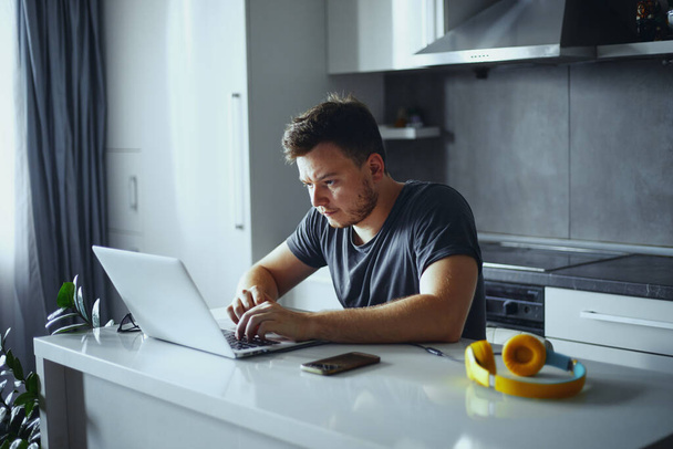 Poważny dorosły mężczyzna freelancer za pomocą laptopa studiuje online pracy z domu - Zdjęcie, obraz