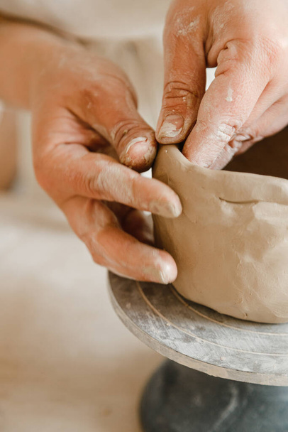 Женские руки гончара делает чашку в традиционном стиле. Руки делают посуду из глины - Фото, изображение