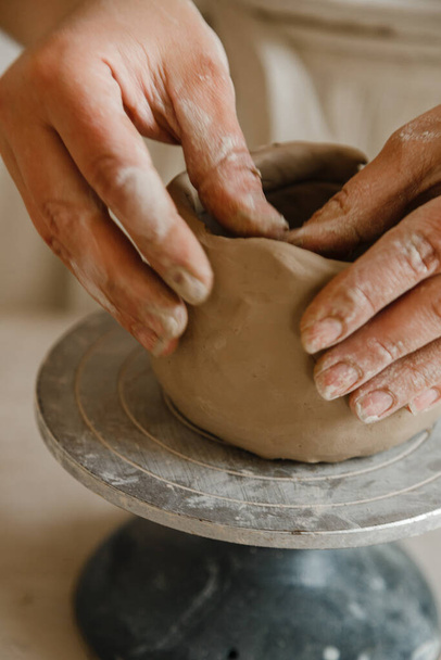 Female hands of potter making cup in traditional style. Hands make dishes from clay - Photo, Image