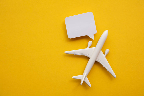 Airplane with a blank speech bubble. Flight feedback and holiday communication background - 写真・画像