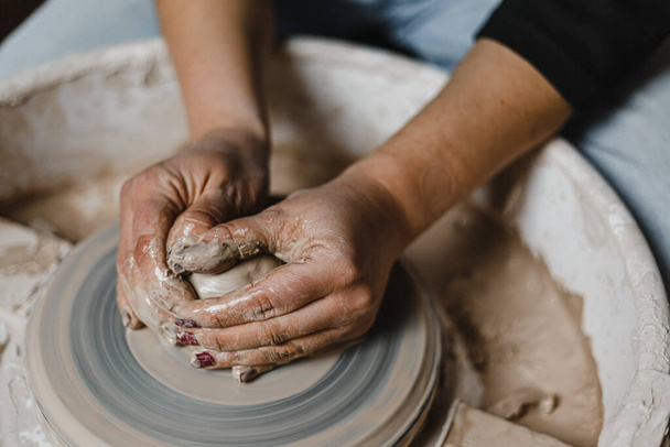 Female hands of potter making cup in traditional style. Hands make dishes from clay - Foto, immagini