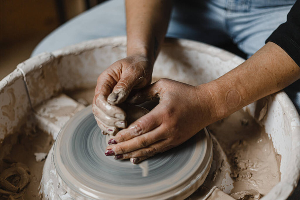 Женские руки гончара делает чашку в традиционном стиле. Руки делают посуду из глины - Фото, изображение