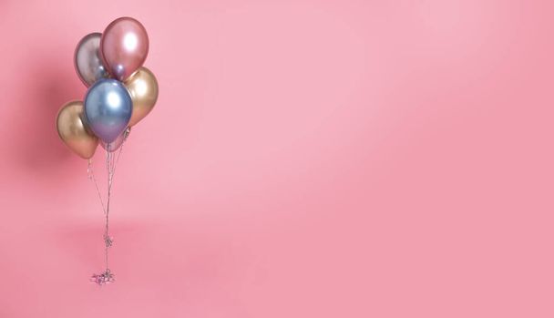barevné helium nafouknuté balónky na růžovém pozadí - Fotografie, Obrázek