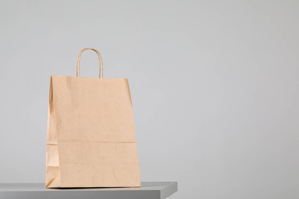 Brown paper bag with handles, empty shopping bag with area for your logo or design, food delivery concept - Foto, Imagen