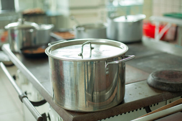 Large pot for cooking. Kitchen utensils in the dining room. Stainless steel water tank. Dishes in the kitchen. - Photo, image