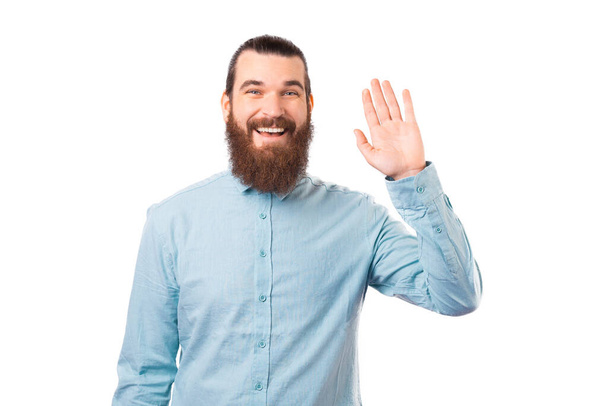 L'uomo barbuto sta facendo un gesto per salutare qualcuno.. - Foto, immagini