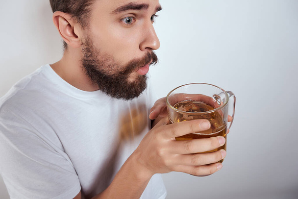 чоловік у білій футболці з кухолькою пива фаст-фуд бар алкоголь ізольований фон
 - Фото, зображення