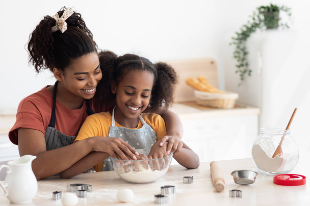 Loving black mother and daughter cooking together - Photo, Image
