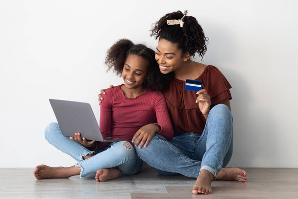 Happy black mother and daughter shopping online together, closeup - Fotoğraf, Görsel