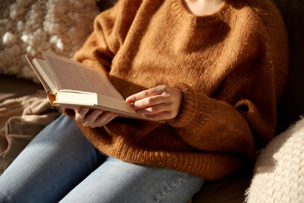 γυναίκα σε ζεστό πουλόβερ ανάγνωση βιβλίο στο σπίτι - Φωτογραφία, εικόνα