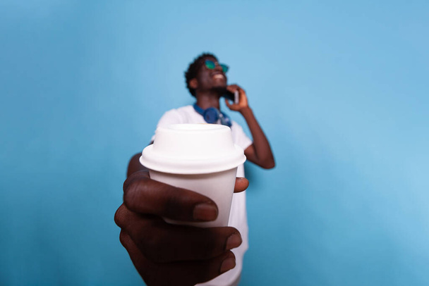 Szczęśliwy człowiek pokazując filiżankę kawy do kamery - Zdjęcie, obraz