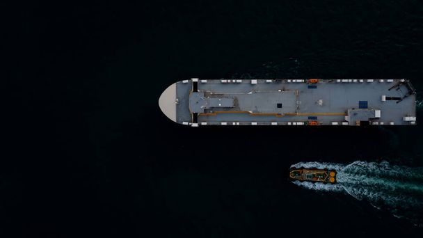 Roll-on Roll-of  ship loading new cars line up . Automotive container carriers floating in sea, business services import export goods international by Roll-on Roll-of ship large in the Ocean freight, photograph at night process aerial top view   - Photo, Image