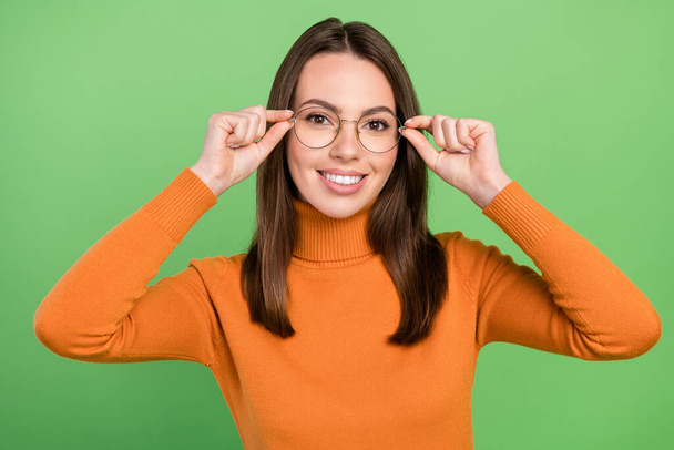 Portrait of attractive cheerful healthy brown-haired girl wearing touching specs isolated over green color background - Fotoğraf, Görsel