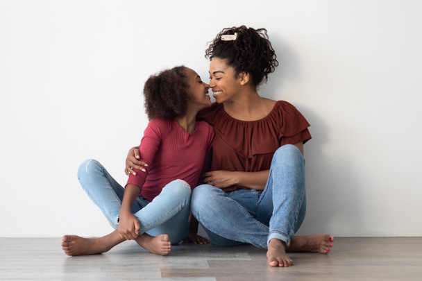 Kochająca czarna rodzina siedzi na podłodze w domu - Zdjęcie, obraz