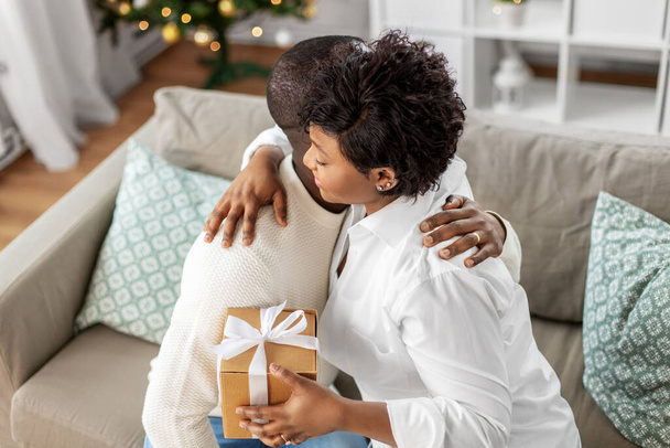 happy african couple with christmas gift at home - Фото, зображення