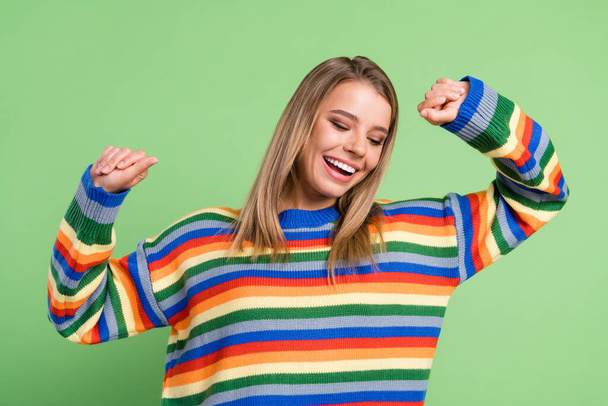 Foto retrato chica sonriente bailando en la fiesta vistiendo suéter bastante aislado pastel color verde fondo - Foto, imagen