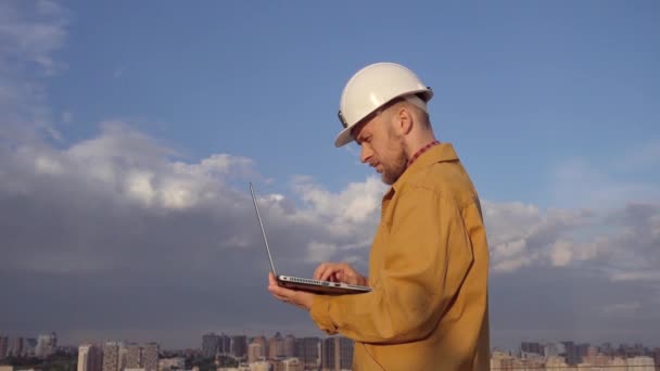Ingenieur op bouwplaats met laptop in stedelijke stad - Video