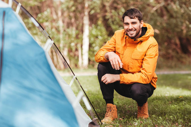 man setting up tent outdoors - Photo, image
