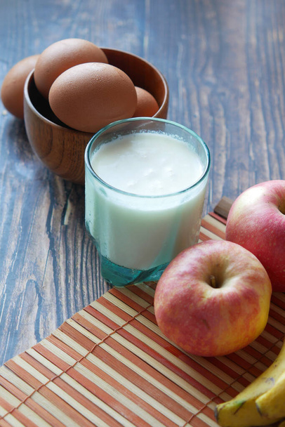 zdravý snack koncept s mlékem, vejcem a jablkem na stole. - Fotografie, Obrázek