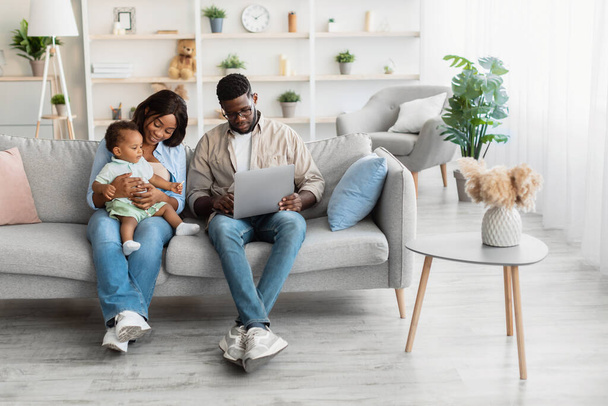 Muotokuva afrikkalainen amerikkalainen perhe käyttää kannettavaa tietokonetta kotona - Valokuva, kuva