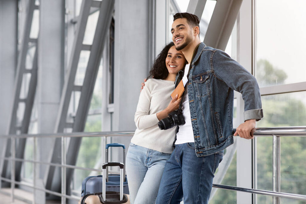 Podróż rodzinna. Romantyczna para arabska czeka na lot w strefie Lounge lotniska - Zdjęcie, obraz