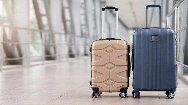 Dos elegantes maletas de pie en la sala vacía del aeropuerto, panorama con espacio para copias - Foto, Imagen