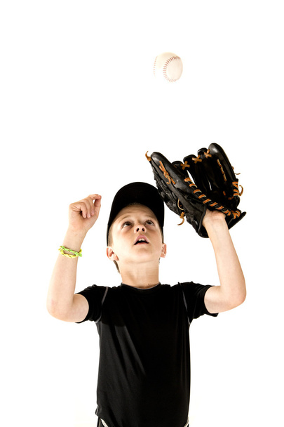 Young boy baseball player focusing on catching the ball - Фото, зображення