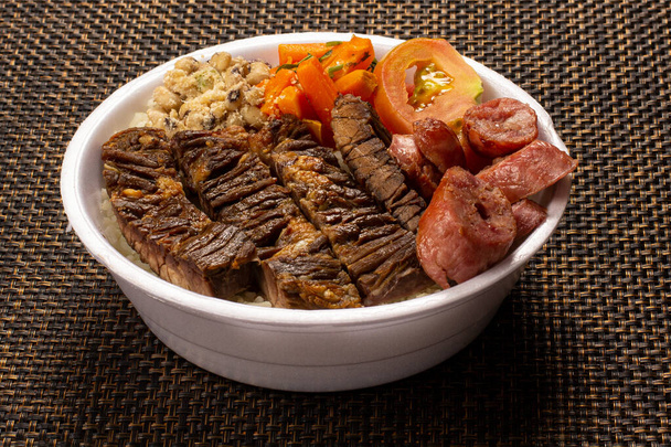 Lunchbox brésilien avec barbecue viande saucisse salade de haricots de riz et farofa - Photo, image