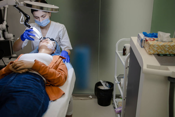 Mulher recebendo tratamento facial com laser e ultrassom em um centro de resort de saúde - Foto, Imagem