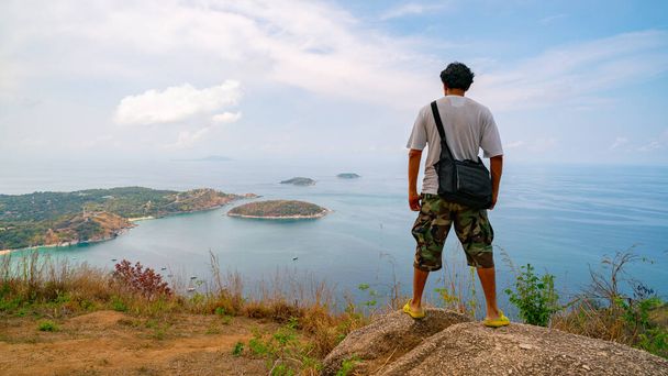 Viaggio uomo fotografo in piedi sulla roccia per vedere la vista del paesaggio a Phahindum punto di vista popolare punto di riferimento a Phuket Thailandia punto di vista per vedere promthep promthep promthep Naiharn spiaggia e yanui spiaggia Vista incredibile. - Foto, immagini