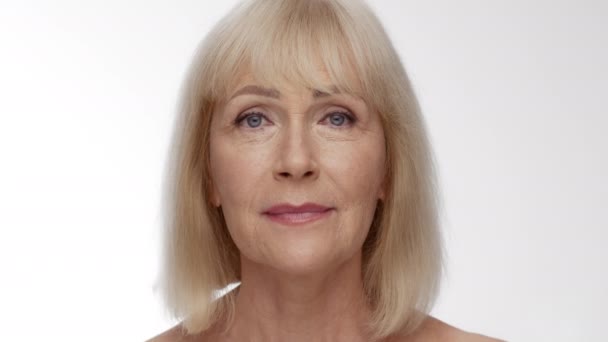 Close up portrait of beautiful senior caucasian woman looking at camera with serious and happy expressions - Footage, Video
