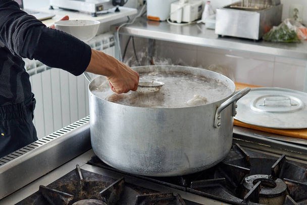 Cook skimming the foam from the surface of the broth  - Foto, Imagem